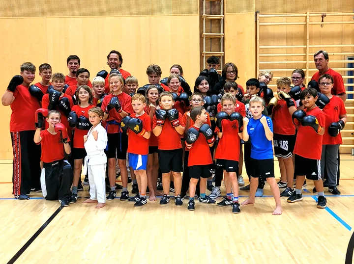 Kinder und Trainer mit Boxhandschuhen beim Kickboxtraining